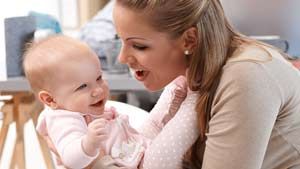 Maman qui tient sa petite fille en train de glousser