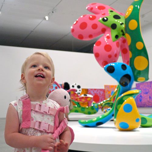 Enfant en bas âge dans une galerie d'art en train de regarder des œuvres d'art