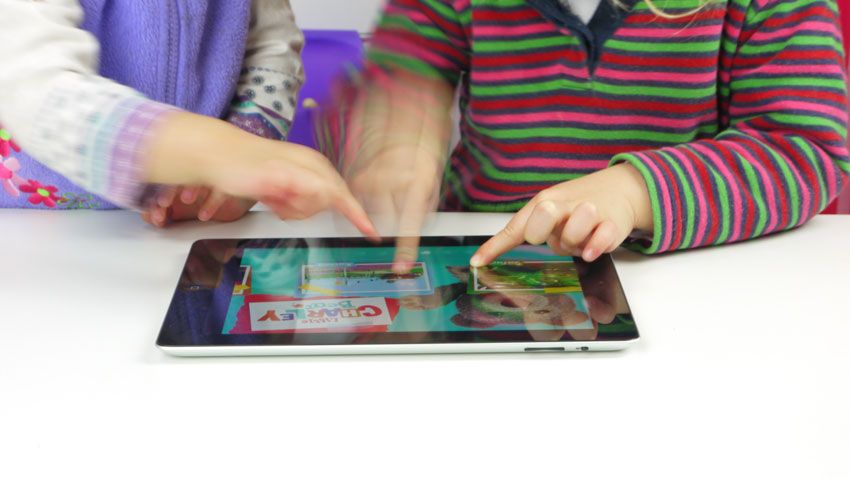 2 enfants en bas âge touchent l'écran d'une tablette