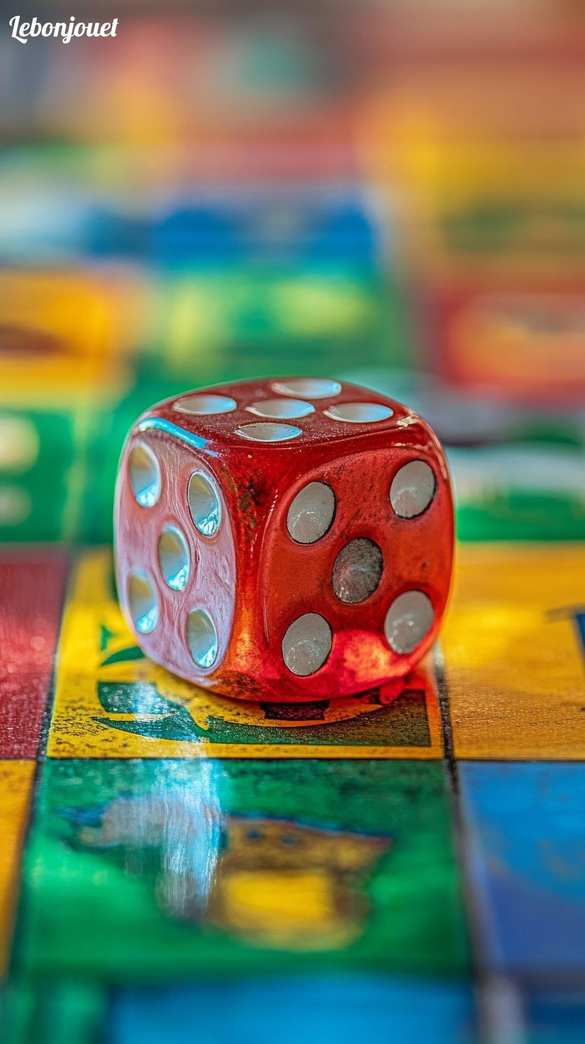 Dé rouge sur cases colorées : symbole du Monopoly, un jeu devenu culte à travers le monde.