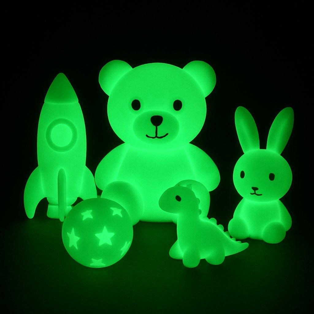 Des enfants émerveillés découvrent les jouets glow-in-the-dark toys children lors d'une séance dans la pénombre.