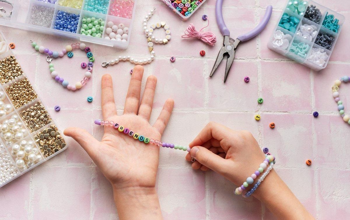 Enfant manipulant des perles à enfiler en intérieur, favorisant la motricité fine et la concentration.