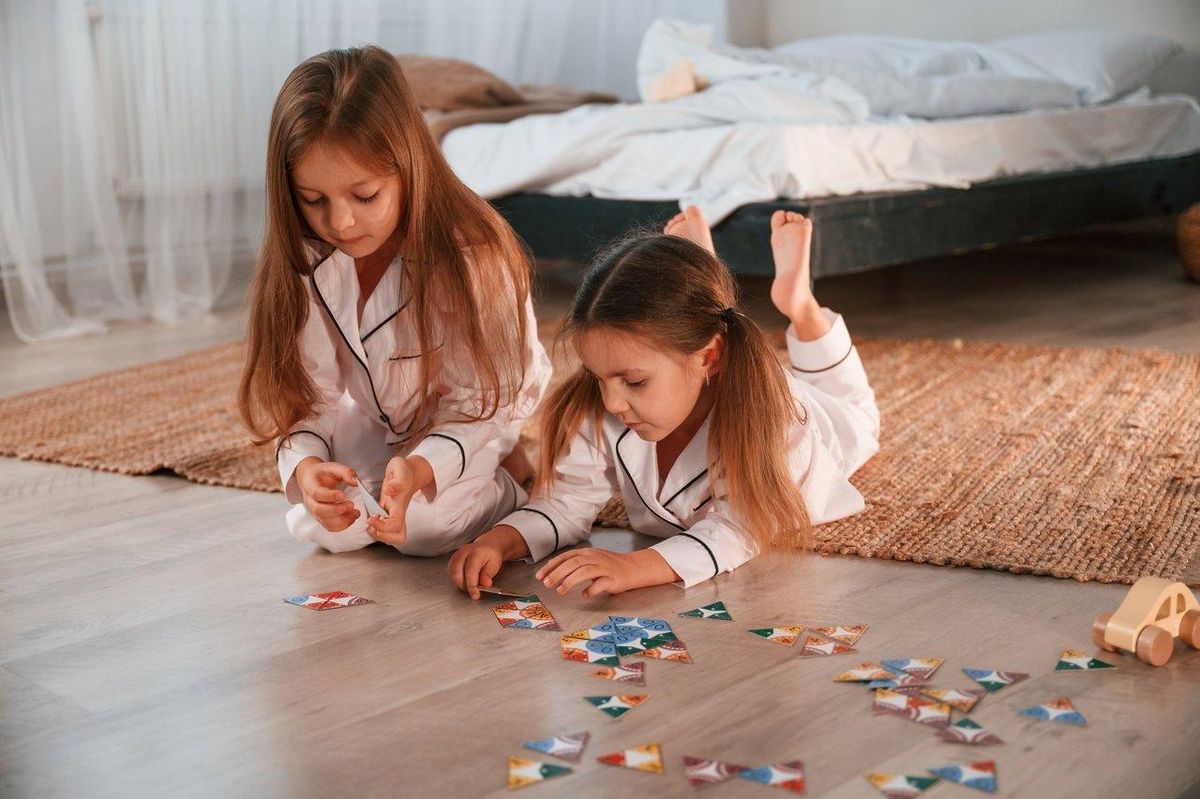 Enfants heureux jouant à un jeu de société familial moderne adapté aux moins de 8 ans.