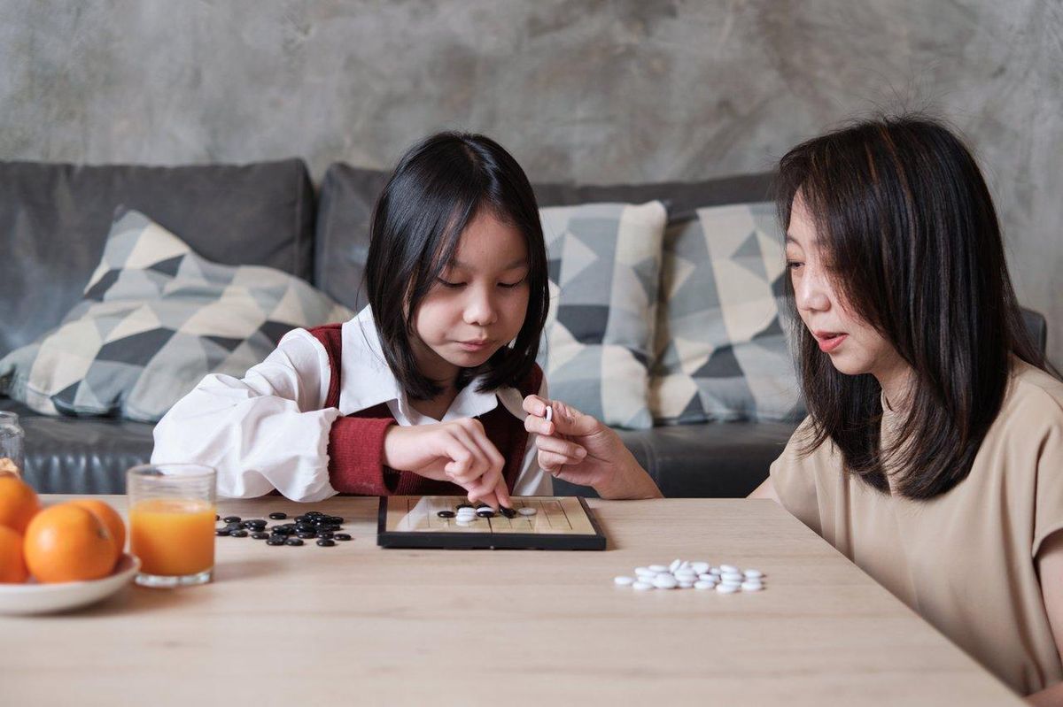 Enfants jouant à des jeux de stratégie en famille, illustrant concentration et plaisir partagé.