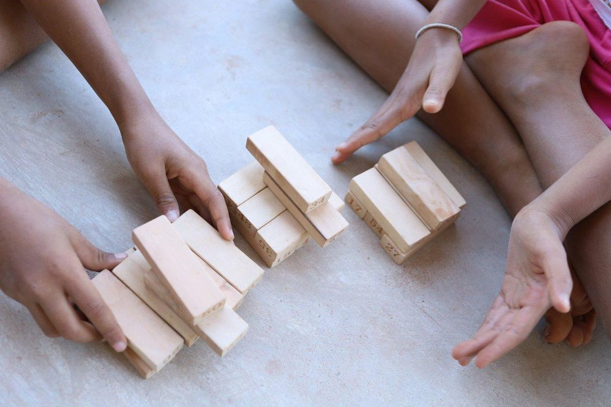 Enfants jouant avec des blocs en bois colorés, favorisant leur développement éducatif et leur créativité.