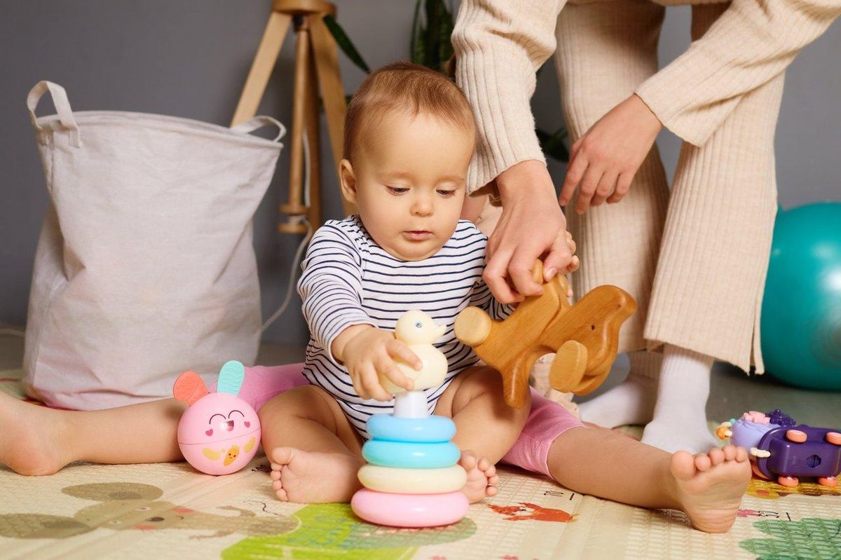 Enfants jouant avec un jouet magnétique d’animaux colorés dans un espace intérieur sécurisé.
