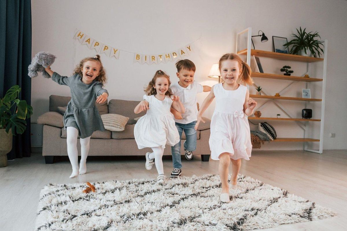 Enfants souriants jouant à des jeux de société lors d’un anniversaire, ambiance festive et conviviale.
