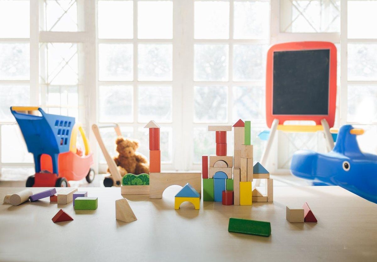 Espace de jeu sécurisé pour enfants avec blocs de construction et pâte à modeler, favorisant l'autonomie.