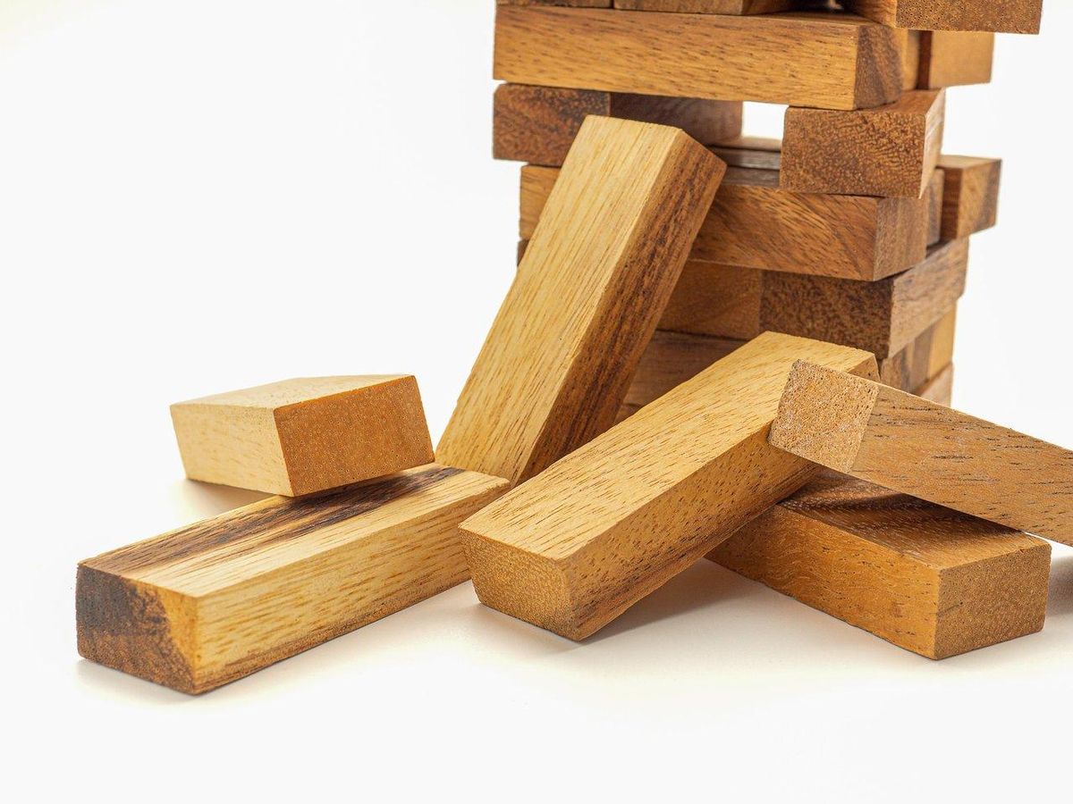 Jeu de construction en bois XXL avec cubes verrouillés sur un plateau en bois massif dans un espace lumineux.