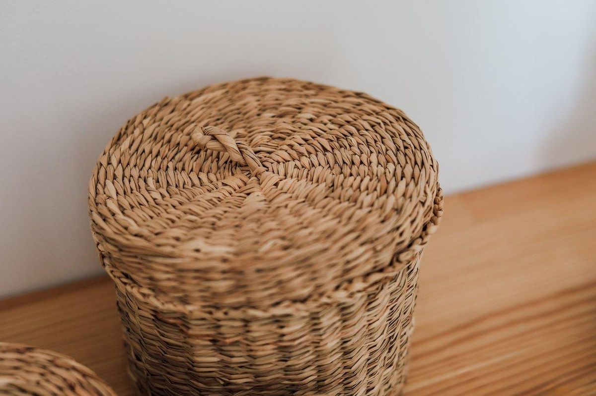 Panier à trésors Montessori en bois, tissu et métal, idéal pour stimuler la découverte chez les enfants de 3 à 6 ans.