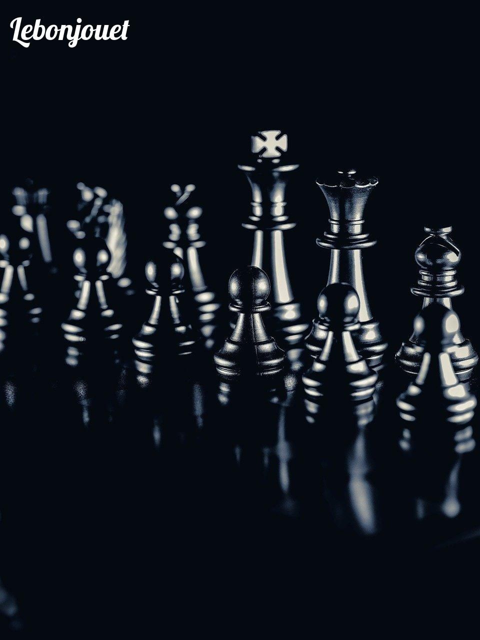 Pièces d'échecs en lumière tamisée : réflexion et stratégie en action.