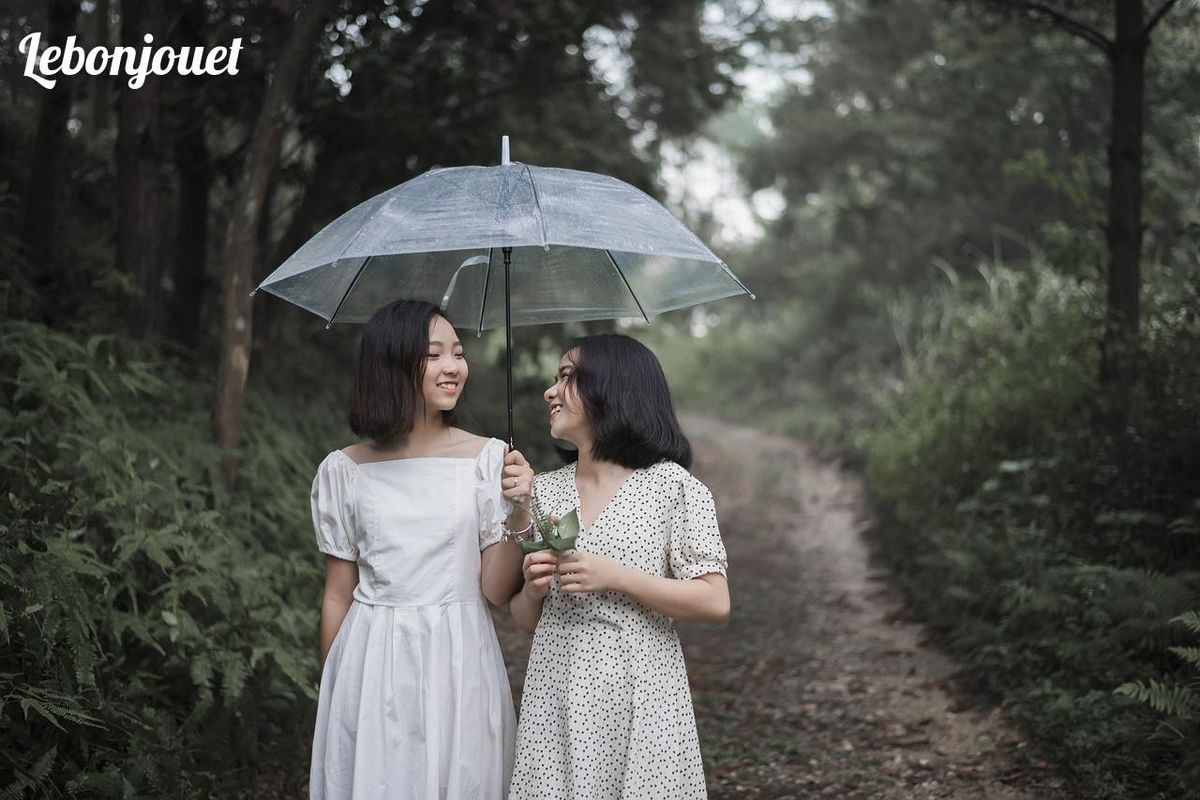 Sous la pluie, un sourire partagé révèle la magie du lien fraternel.