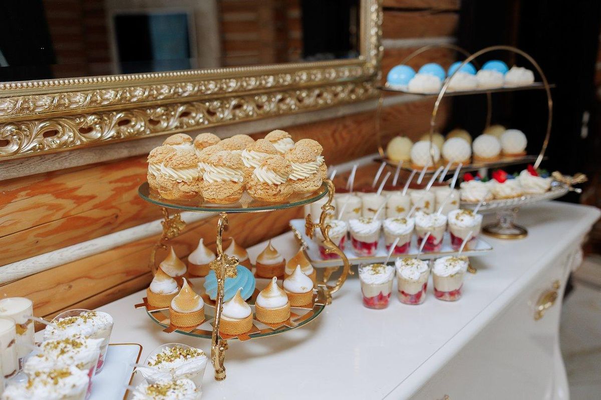 Table d’anniversaire féérique La Reine des Neiges avec Rainbow Cake bleu, cupcakes glacés, sablés flocons et figurines Elsa et Anna dans une ambiance hivernale lumineuse.