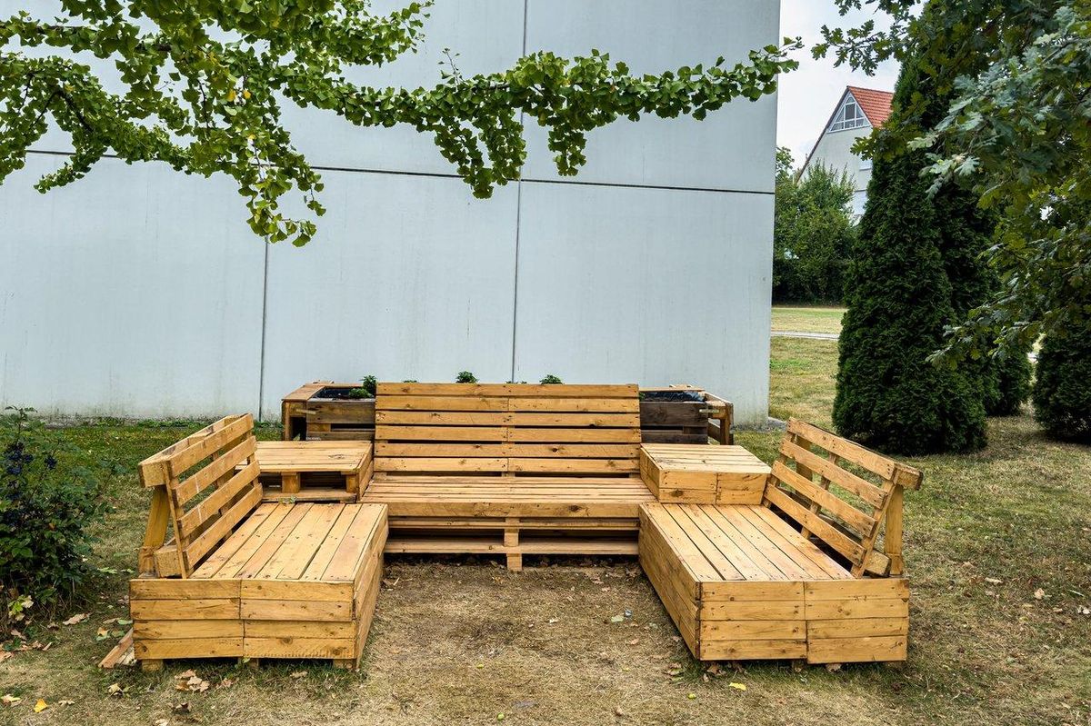 Un atelier de jardin miniature en recycled wood, parfait pour les enfants, dans un espace extérieur convivial.