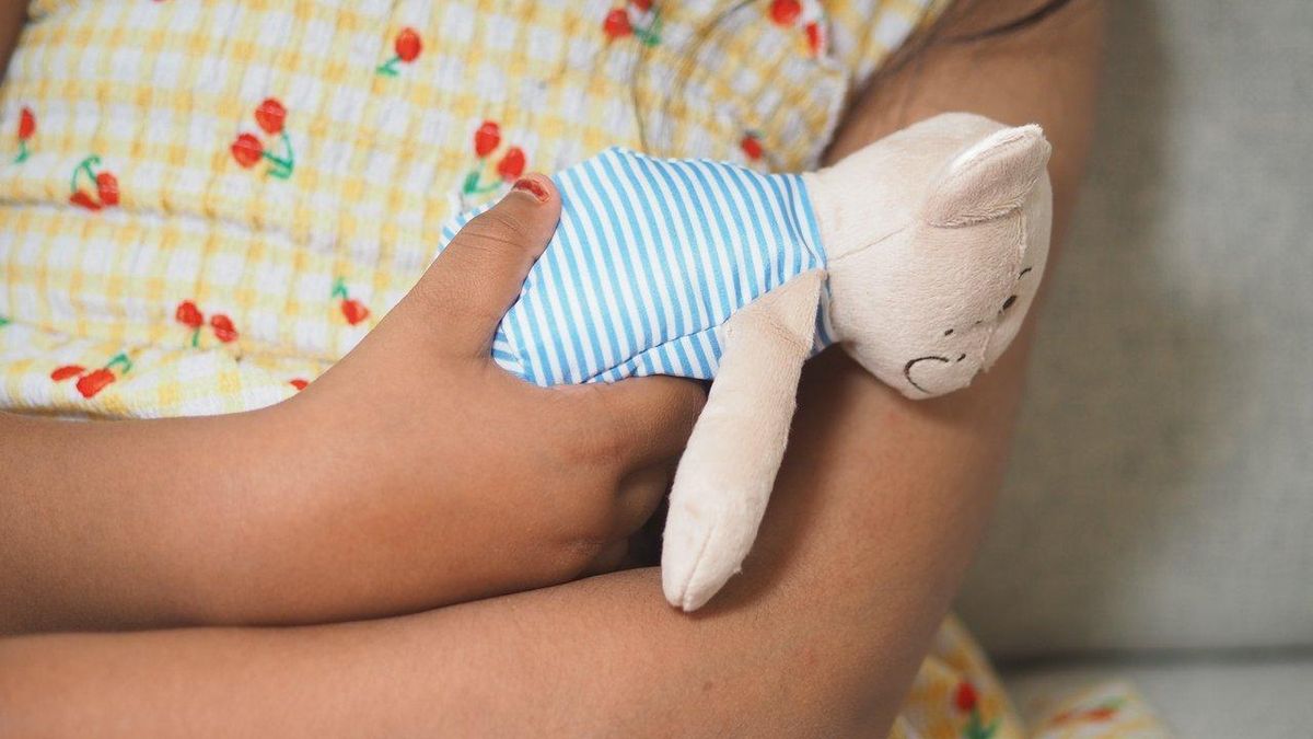 Un bébé confortablement blotti contre son doudou, source d'apaisement et de sécurité à la maison.