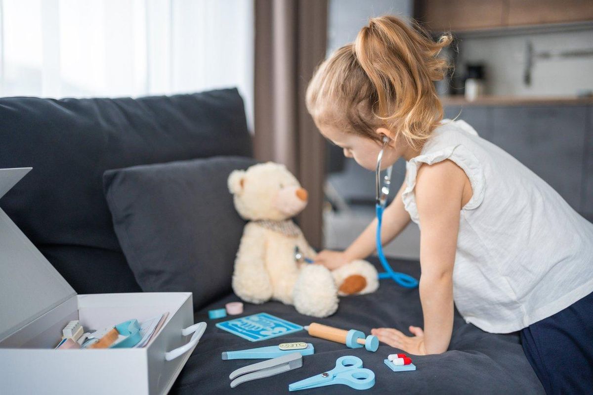 Un enfant joue avec un kit de docteur en bois, stimulant son imagination dans un espace lumineux et coloré.