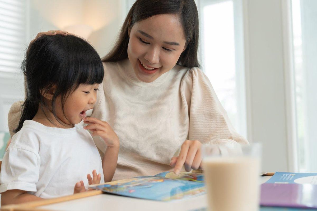 Un parent et son enfant lisent ensemble un livre Disney, transmettant des valeurs de bienveillance.