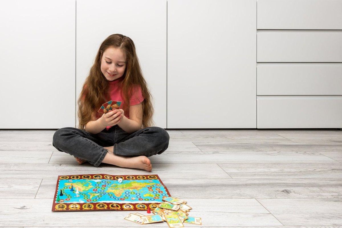 Une enfant souriante joue avec des cartes Pokémon et des figurines lors du Black Friday 2025.