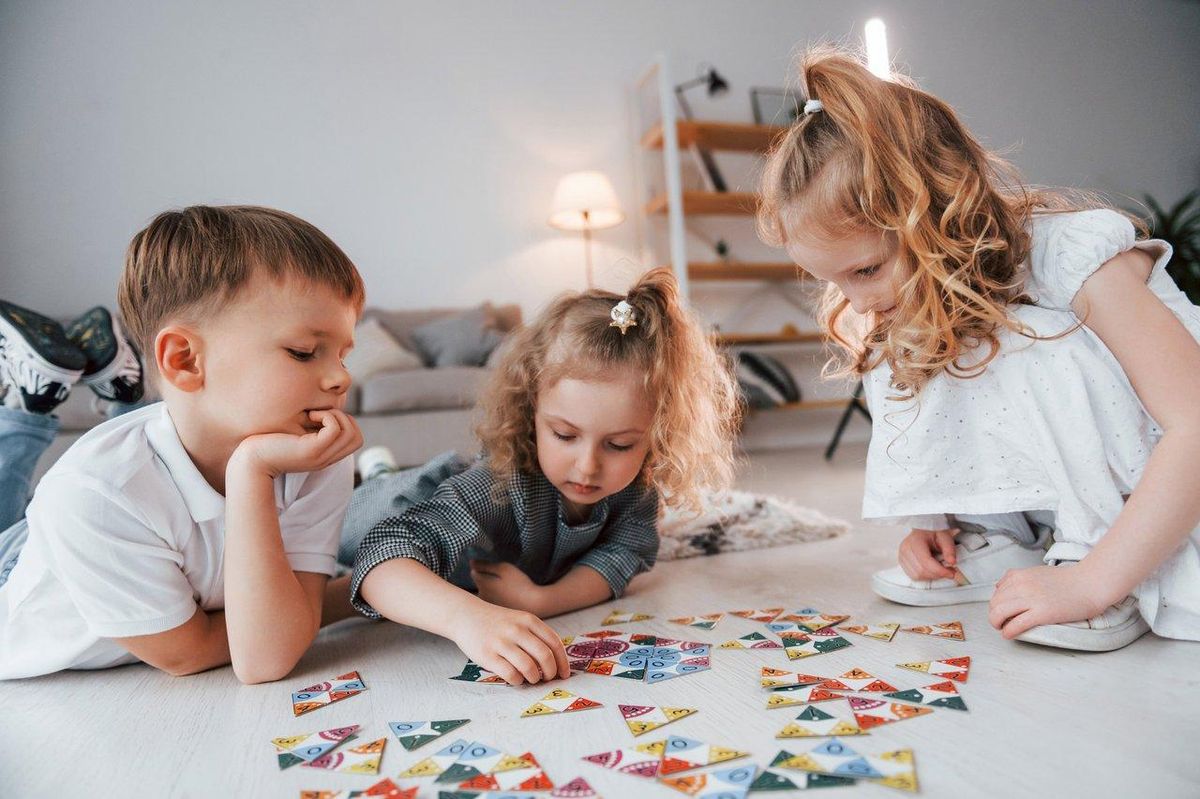 Une scène conviviale avec des enfants jouant ensemble à des jeux de société coopératifs pour stimuler leur imagination.