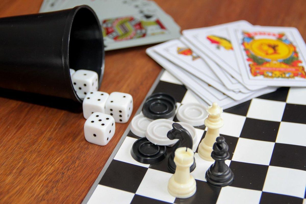 Une variété colorée de jeux de société pour la rentrée scolaire 2025, incluant cartes, dominos et échecs.