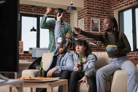 Groupe d’amis jouant en réalité virtuelle, avec manettes et lunettes VR pour une expérience gaming immersive.