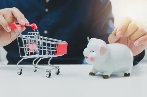 Économies et budget : un homme compare promotions, panier d’achat et tirelire pour mieux investir.