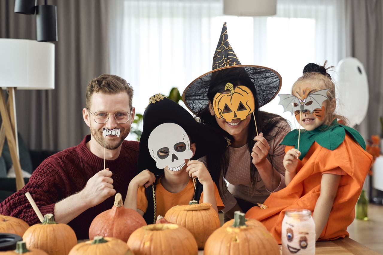 Bébé déguisé en citrouille pour Halloween, ambiance familiale chaleureuse et festive autour de la table.