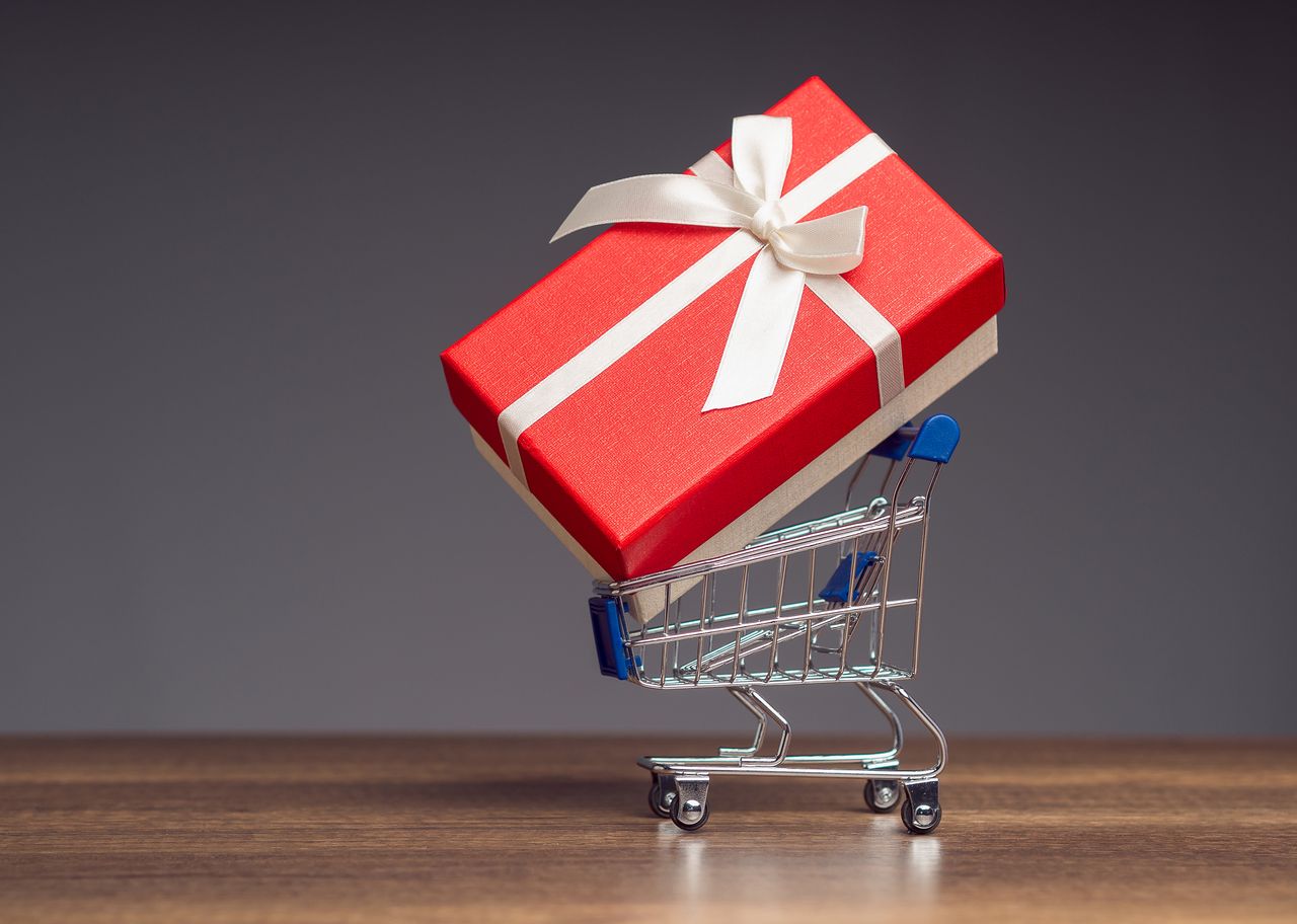 Cadeau dans un panier d’achat, symbole d’e-commerce, de vente en ligne et d’idée cadeau.