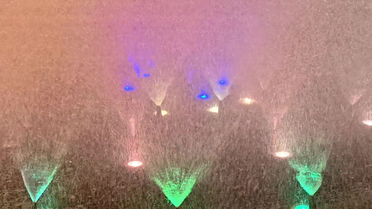 Disney Adventure World de nuit : spectacle Disney Cascade of Lights, fontaines illuminées et projections sur l’eau.