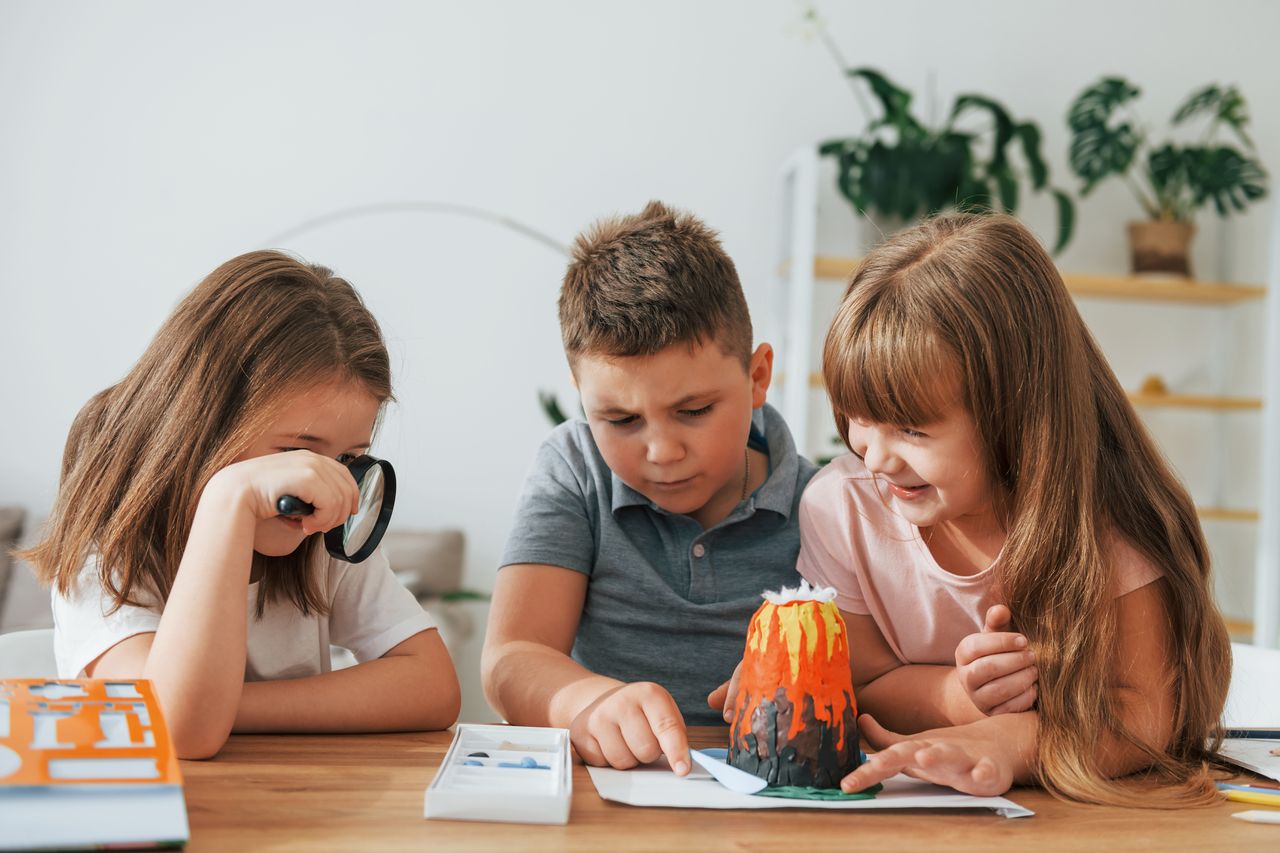 Enfant créant un volcan en mousse avec des ingrédients du quotidien lors d’une expérience ludique à la maison.