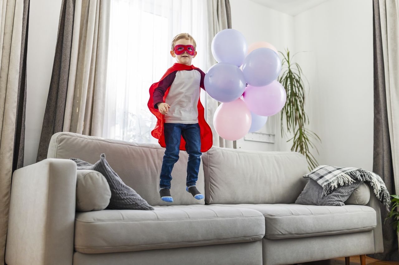 Enfant déguisé en super-héros, entouré de ballons, pour une fête d’anniversaire sur le thème Avengers Marvel.