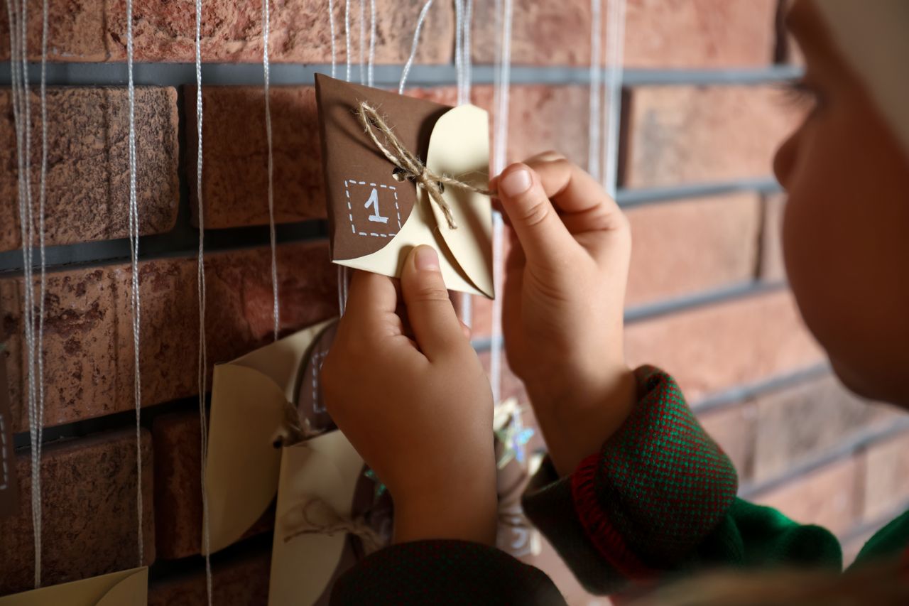 Enfant ouvrant une case de son calendrier de l'Avent