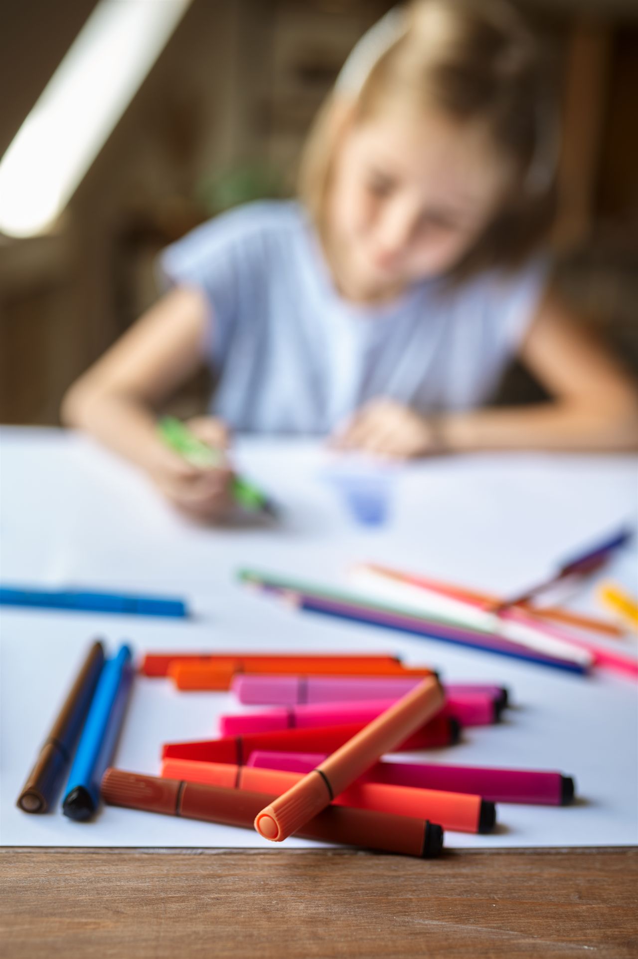 Enfant personnalise un stylo dans un atelier créatif coloré avec perles, encres et papeterie