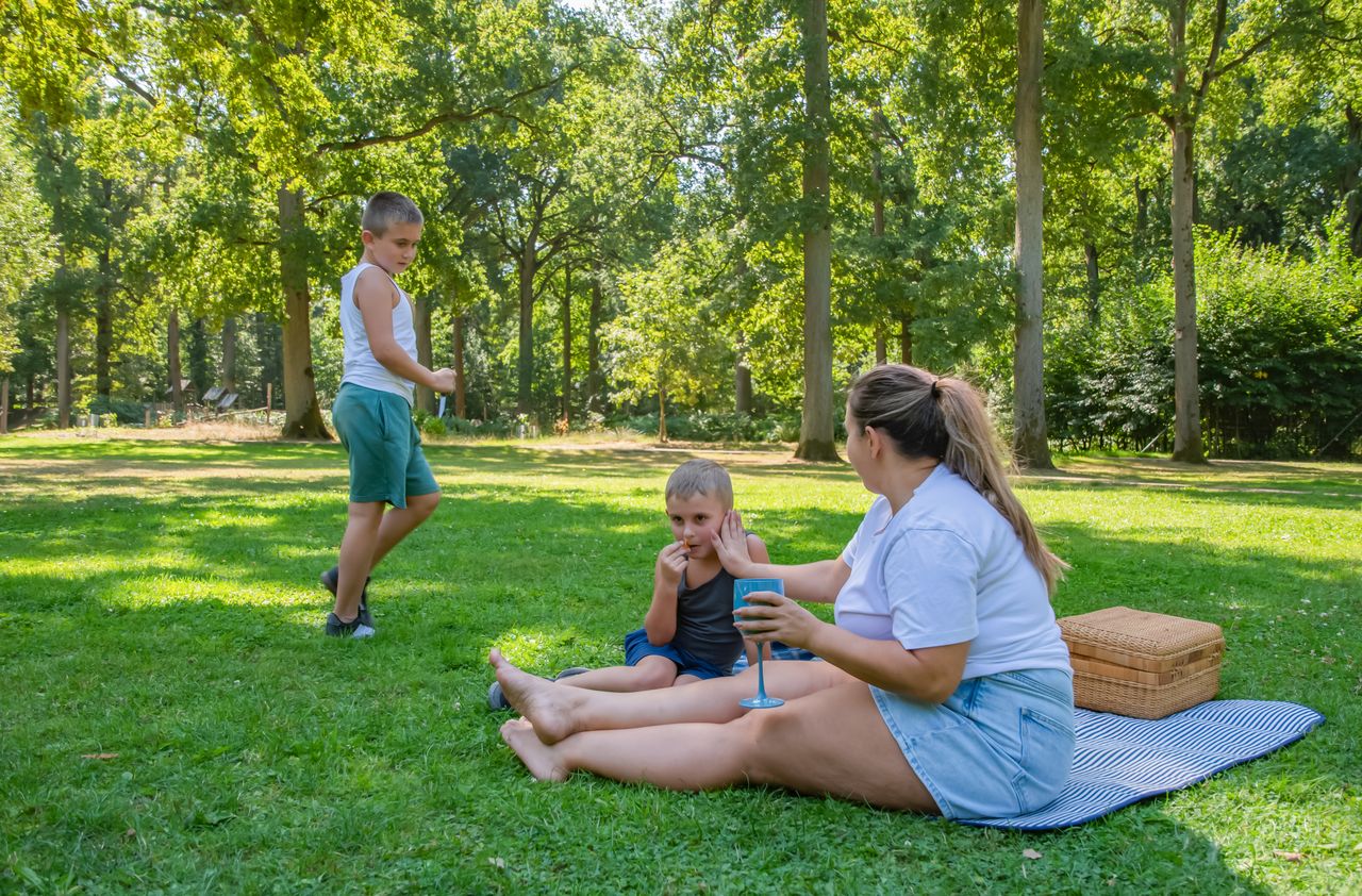 Famille avec enfants profitant d’un concert de plein air en fin de journée, ambiance estivale et conviviale