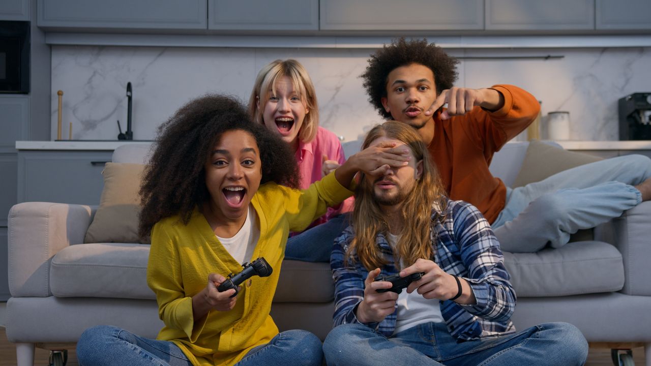 Groupe d'amis jouant à la console, victoire festive et compétition amicale à la maison.