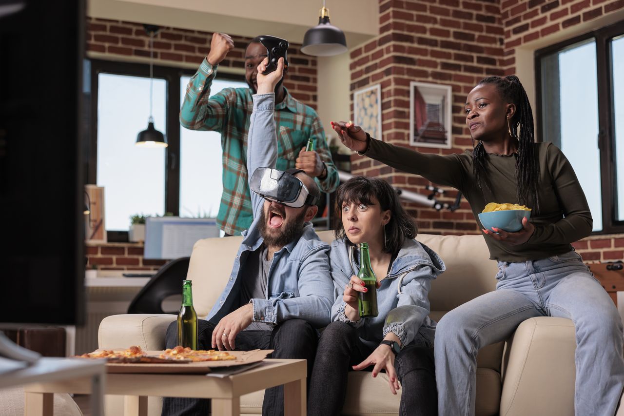 Groupe d’amis jouant en réalité virtuelle, avec manettes et lunettes VR pour une expérience gaming immersive.