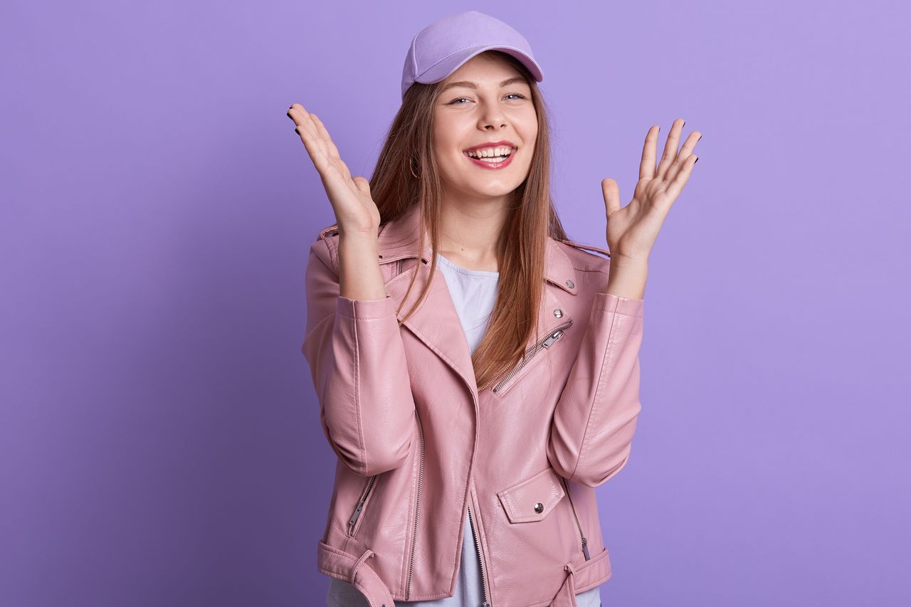 Jeune adolescente souriante en tenue rose sur fond lilas, idéale pour la catégorie Violetta.