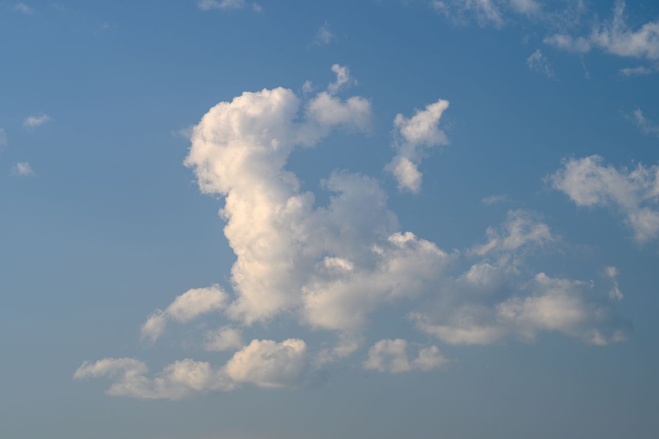 Jirachi dans Pokémon Pokopia devant un Centre Pokémon, sous un ciel étoilé et nuageux.