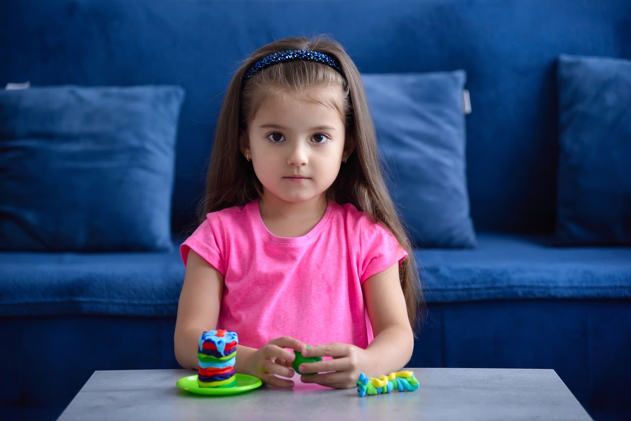 Petite fille créative jouant avec de la pâte à modeler, inspirée par l’univers Vaiana Disney.