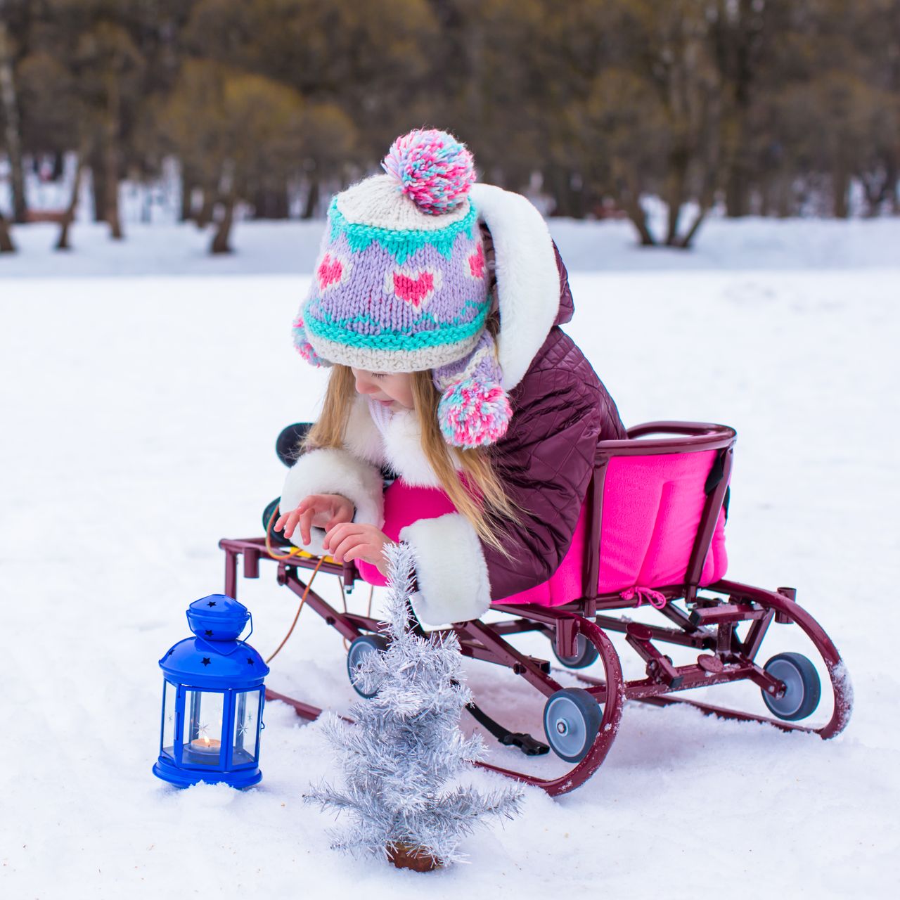 Petite fille heureuse en tenue d'hiver, idéale pour illustrer la magie La Reine des Neiges.