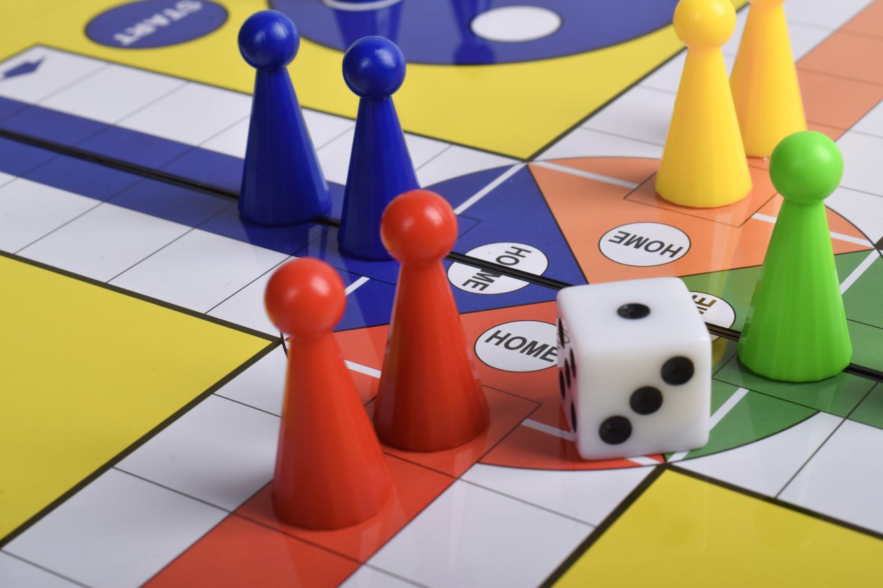 Pions colorés et dés sur un plateau Monopoly, prêts pour une partie conviviale en famille.