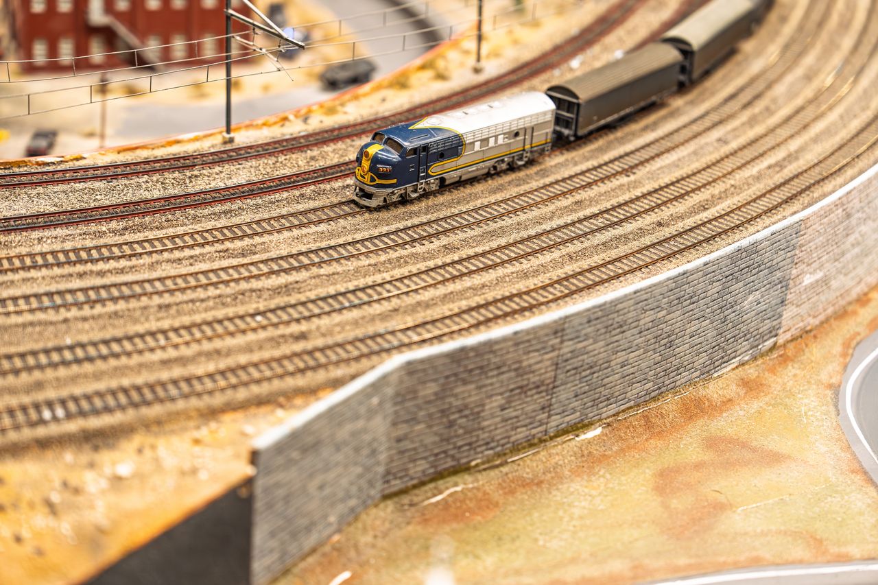 Réseau de modélisme ferroviaire avec un train miniature sur une voie courbe et son décor