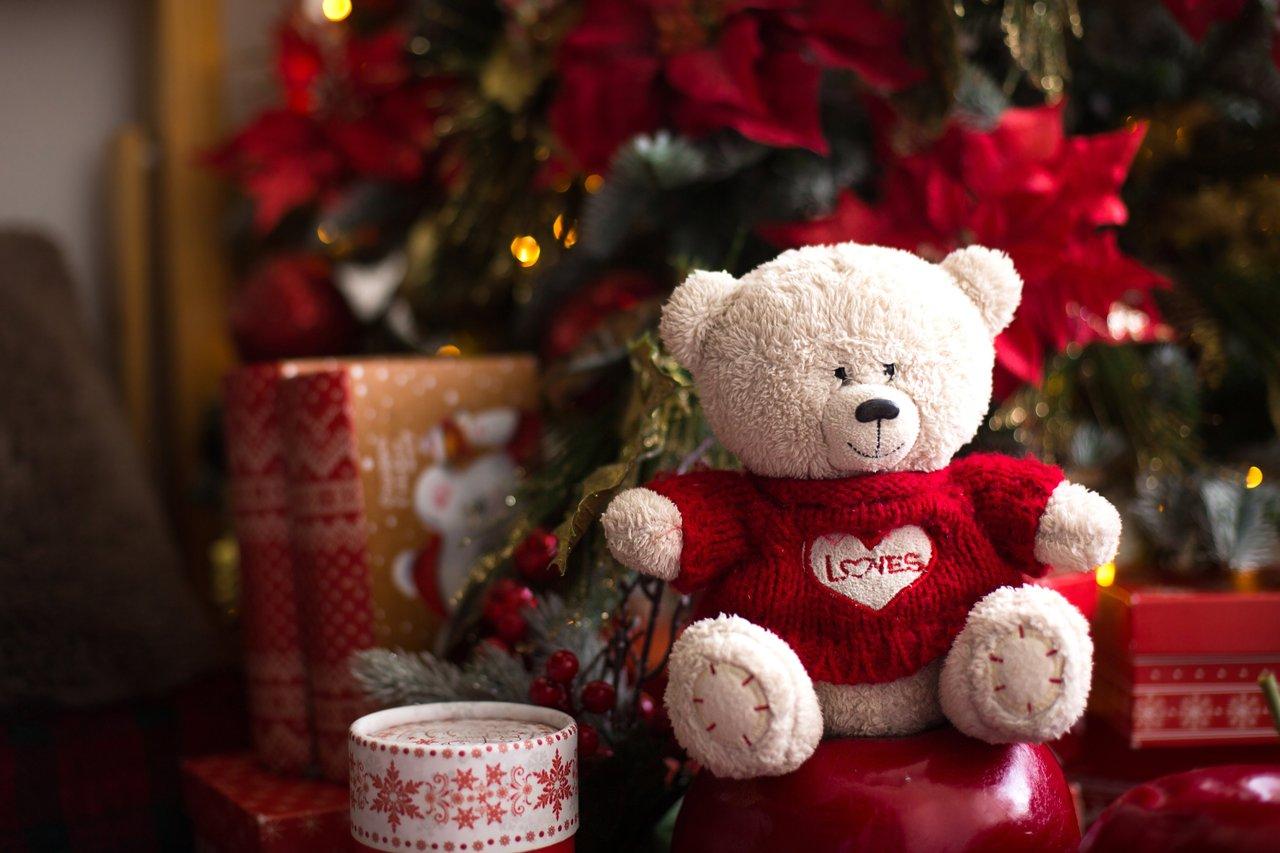 Cadeaux Disney de Noël 2025 : ourson en peluche blanc et décorations festives autour du sapin.