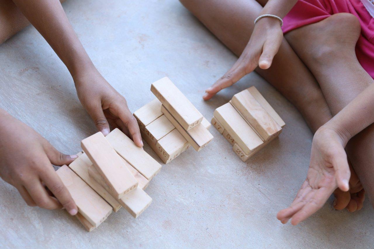 Enfants jouant avec des blocs en bois colorés, favorisant leur développement éducatif et leur créativité.