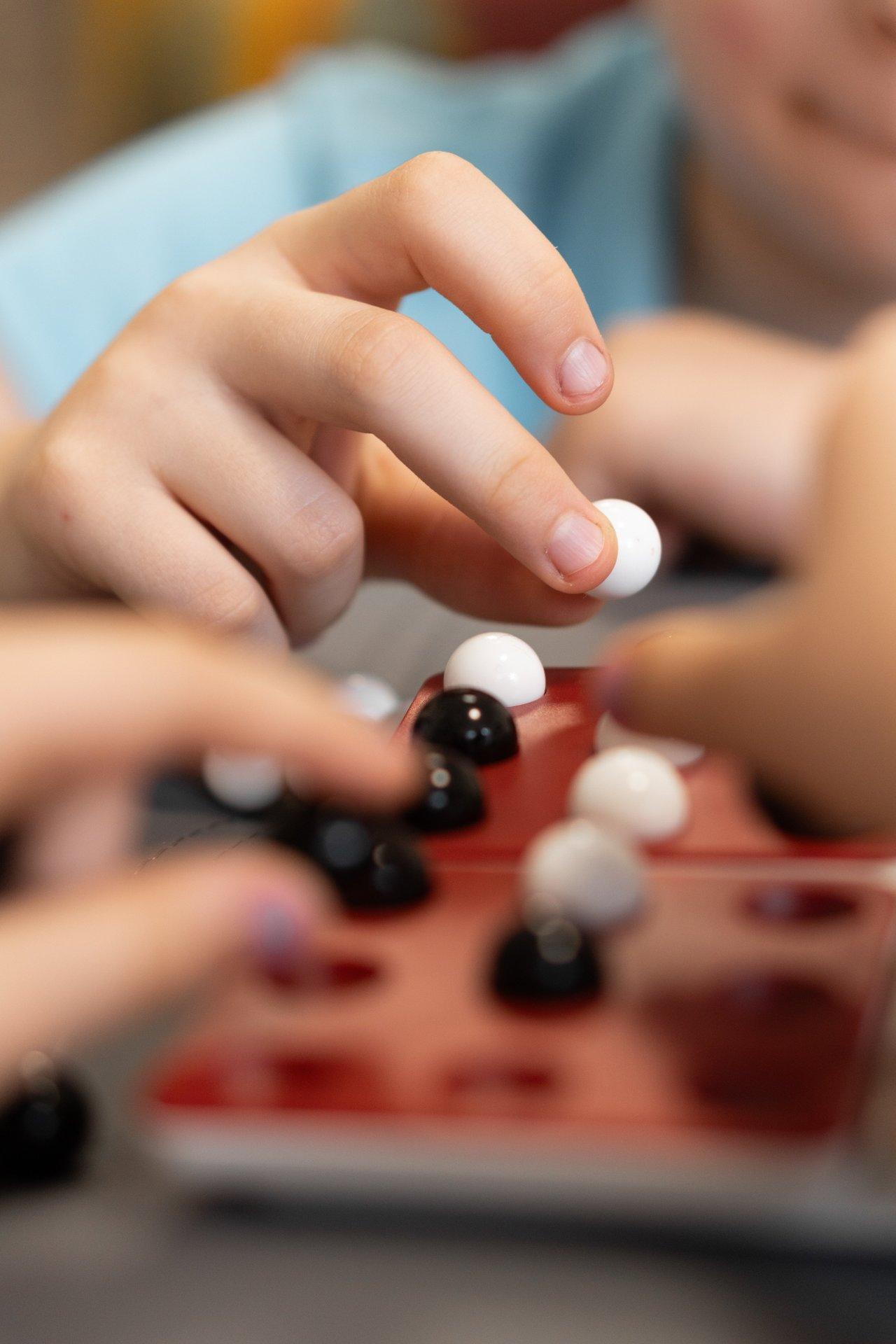 Children playing board game évolutif, favorisant l'apprentissage progressif et l'engagement selon l'âge.
