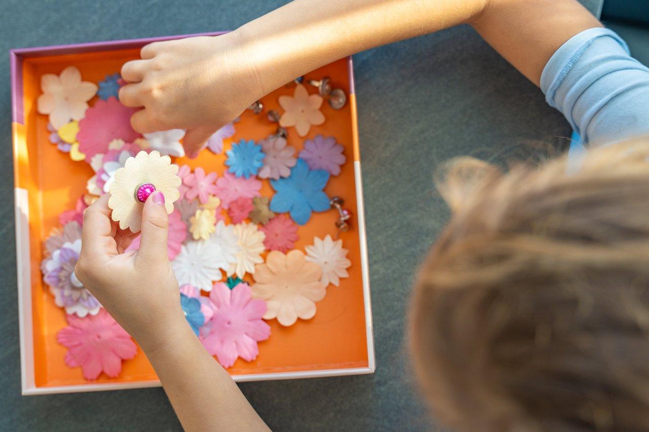 Enfants participant à un kids DIY craft workshop avec des fleurs en papier coloré et matériaux recyclés.