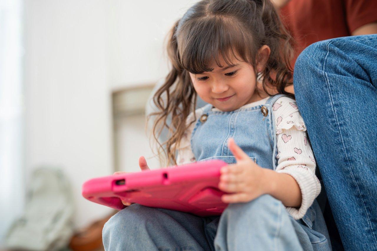 Un toddler utilisant une educational tablet robuste dans un environnement sécurisé et ludique à la maison.
