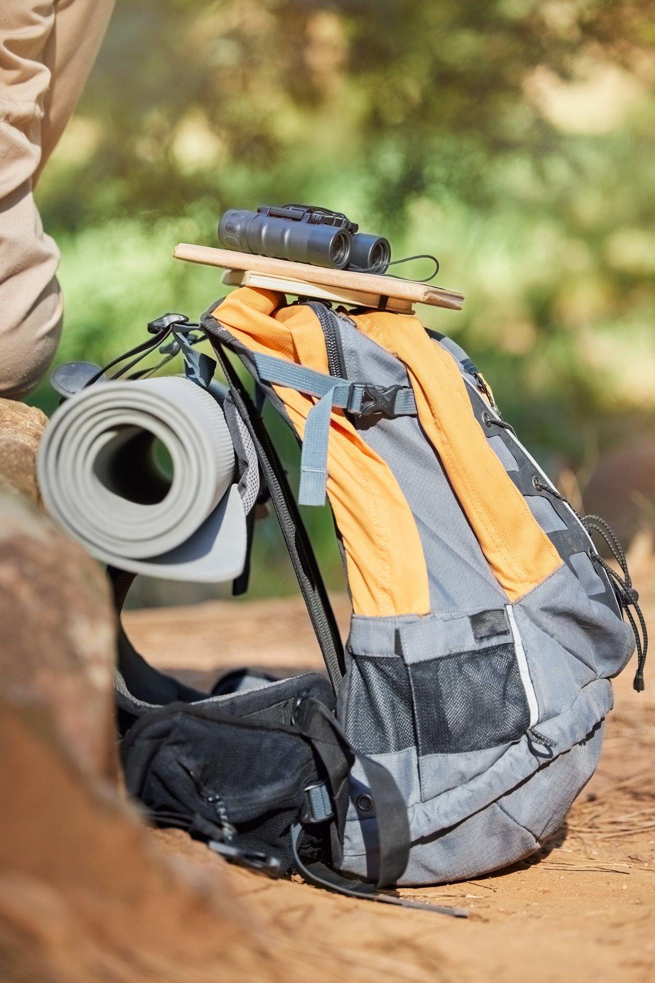 Traceur GPS compact fixé discrètement sous le cartable d’un enfant pour assurer sa sécurité lors des déplacements.