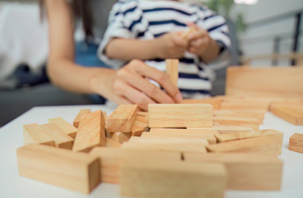 Enfants concentrés lors d'un atelier de construction collaborative avec des briques LEGO, favorisant créativité et développement.