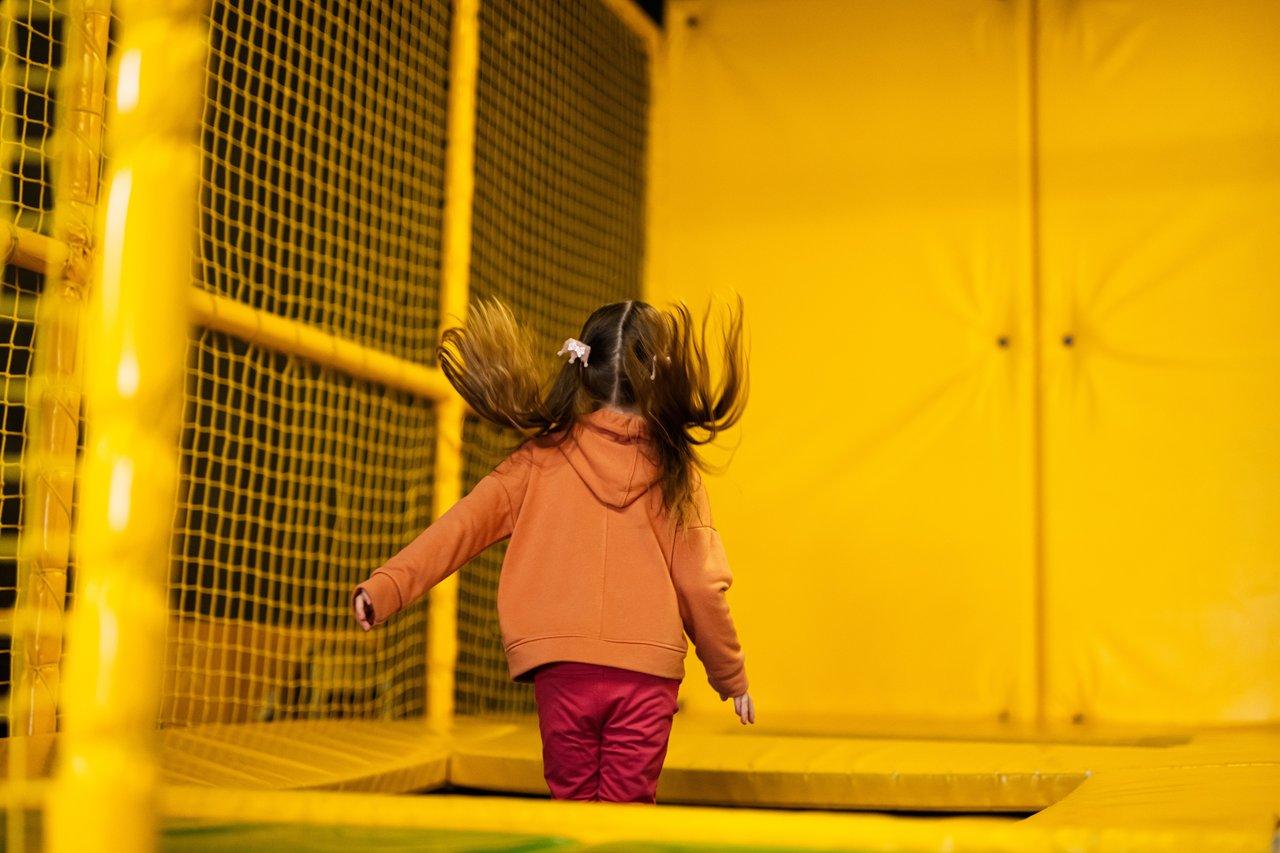 Enfants enthousiastes profitant d'un espace de jeux intérieur avec trampoline pour des activités créatives et sportives.